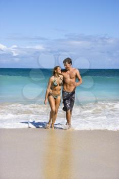 Royalty Free Photo of a Couple Embracing and Smiling as They Walk Out of Water in Maui, Hawaii