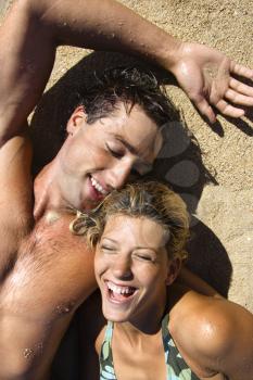 Royalty Free Photo of a Smiling Happy Couple Lying in the Sand on Maui, Hawaii Beach