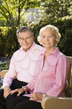 Royalty Free Photo of an Older Couple Sitting on a Bench Smiling