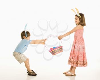 Royalty Free Photo of a Boy and Girl Wearing Bunny Ears Fighting Over an Easter Basket