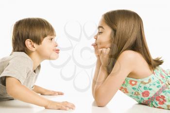 Royalty Free Photo of a Girl and Boy Sticking Their Tongues Out at Each Other 