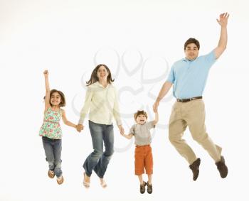 Family jumping and smiling while holding hands.