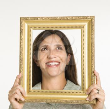 Royalty Free Photo of a Woman Holding a Frame in Front of Her Face and Smiling