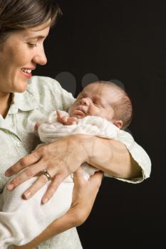 Royalty Free Photo of a Mother Smiling Holding Her Baby
