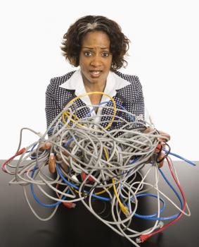 Royalty Free Photo of a Businesswoman Holding a Bundle of Tangled Computer Cords