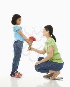 Royalty Free Photo of a Girl Handing a Bouquet of Flowers to Her Mother