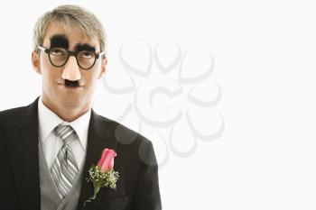 Royalty Free Photo of a Groom Wearing Groucho Glasses Looking Up