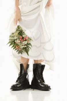 Royalty Free Photo of a Bride Holding a Bouquet Down by Her Black Combat Boots