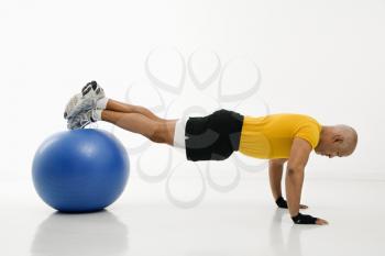 Royalty Free Photo of a Man Doing Pushups While Balancing on an Exercise Ball