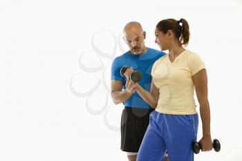 Royalty Free Photo of a Smiling Man Assisting a Woman With Dumbbells