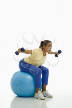 Royalty Free Photo of a Woman Balancing on an Exercise Ball With Outstretched Arms Holding Dumbbells