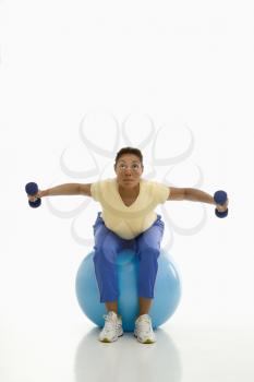 Royalty Free Photo of a Woman Balancing on a Blue Exercise Ball Holding Dumbbells 