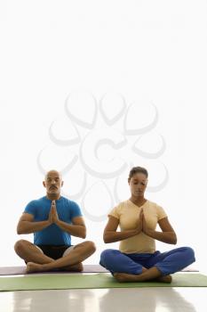 Royalty Free Photo of a Man and Woman Sitting in Namaste Position on Exercise Mats