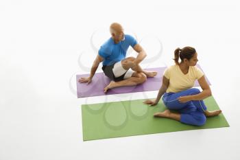 Royalty Free Photo of a Man and Woman Sitting and Stretching on Exercise Mats