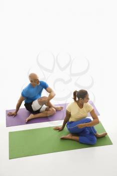 Royalty Free Photo of a Man and Woman Sitting and Stretching on Exercise Mats