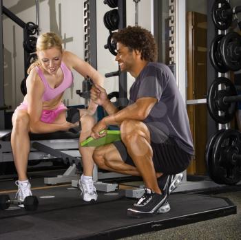 Royalty Free Photo of a Woman Lifting Weights While Her Trainer Watches