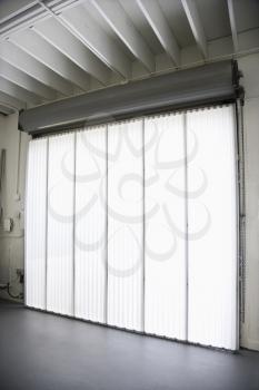 Royalty Free Photo of a Warehouse Building With a Large Window and Blinds