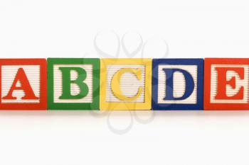 Royalty Free Photo of Alphabet Toy Building Blocks Lined Up in a Row