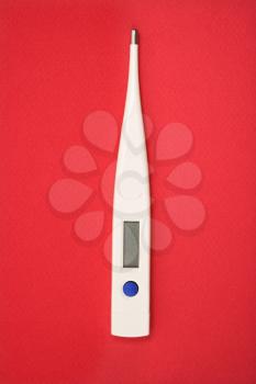 Royalty Free Photo of a Digital Thermometer on a Red Background