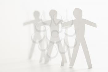Royalty Free Photo of Cutout Paper Men Standing Holding Hands