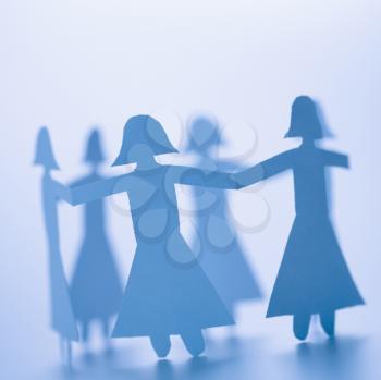 Royalty Free Photo of a Cutout Paper Females Standing Holding Hands