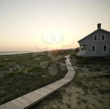 Royalty Free Photo of a Coastal Beach House With a Wooden Boardwalk at Bald Head Island, North Carolina
