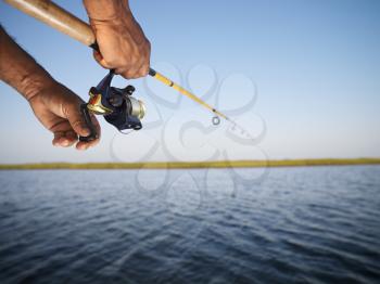 Royalty Free Photo of Male Hands Holding a Fishing Rod
