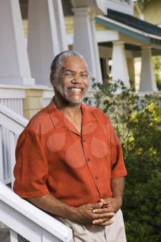 Royalty Free Photo of a Man Standing on a Porch Smiling