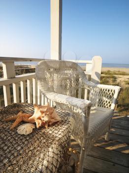 Royalty Free Photo of a Wicker Chair and Sea Shells on a Table