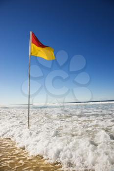 Royalty Free Photo of a Red and Yellow Flag on a Beach in Surfers Paradise, Australia