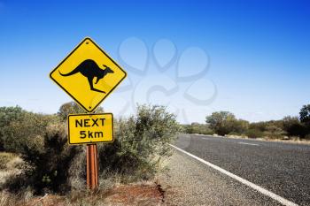 Royalty Free Photo of a Kangaroo Crossing Sign by a Road in Rural Australia