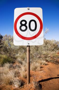 Royalty Free Photo of an Australian Kilometer Per Hour Speed Limit Sign by a Rural Dirt Road
