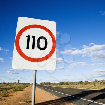 Royalty Free Photo of a Speed Limit Kilometer Per Hour Road Sign by a Road in Rural Australia