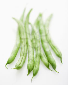 Selective focus shot of green beans on white background.