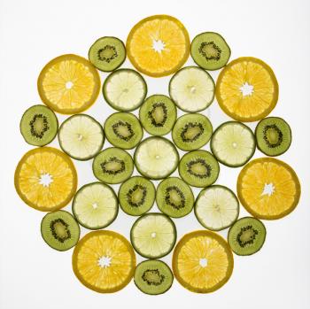 Assorted fruit slices arranged in pattern on white background.