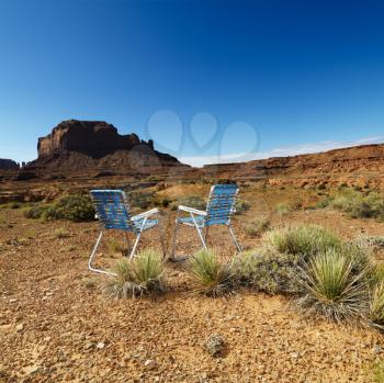 Royalty Free Photo of Lawn Chairs in the Desert With Mesa Land Formation
