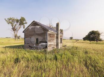Royalty Free Photo of a Dilapidated Wooden House in a Rural Field
