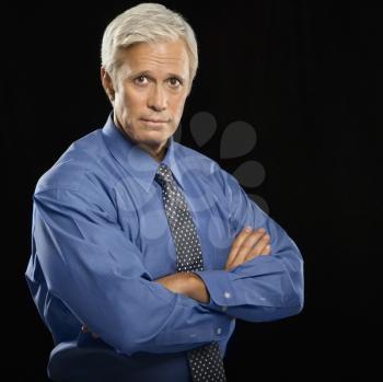 Royalty Free Photo of a Middle-Aged Businessman Standing With Arms Crossed