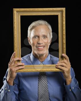 Royalty Free Photo of a Businessman Smiling Through an Empty Picture Frame 