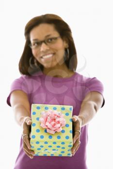 Royalty Free Photo of an African American Woman Holding a Wrapped Package Outwards