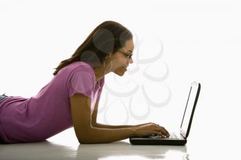 Royalty Free Photo of a Woman Lying on the Floor Using a Laptop 