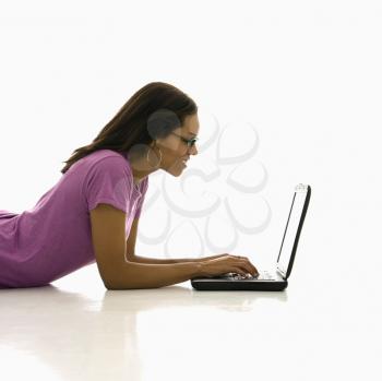 Royalty Free Photo of a Woman Lying on the Floor Using a Laptop