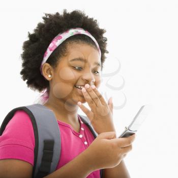 Royalty Free Photo of a Girl With Backpack Reading a Text Message From a Cellphone