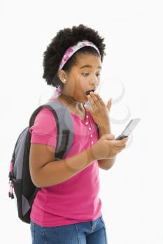 Royalty Free Photo of a Girl With Backpack Reading a Text Message From a Cellphone