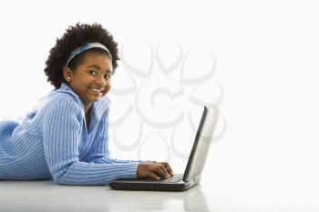 Royalty Free Photo of a Girl Lying on the Floor Using a Laptop