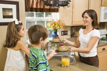 Royalty Free Photo of a Family in The Kitchen With Breakfast