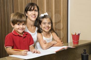 Royalty Free Photo of a Mother and Children Smiling While Doing Homework
