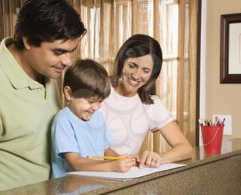 Royalty Free Photo of Parents Helping Their Son With Homework