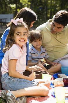 Royalty Free Photo of a Girl Smiling With Her Family Picnicking in the Park