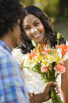 Royalty Free Photo of a Man Giving a Smiling Woman a Bouquet of Flowers